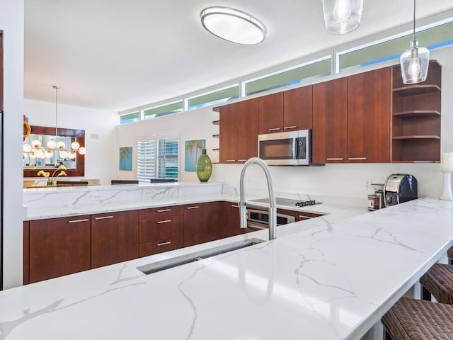 6512 Midnight Pass Rd Unit 301, Sarasota, FL 34242 - kitchen with open shelves, stainless steel microwave, a peninsula, light stone counters, and a sink