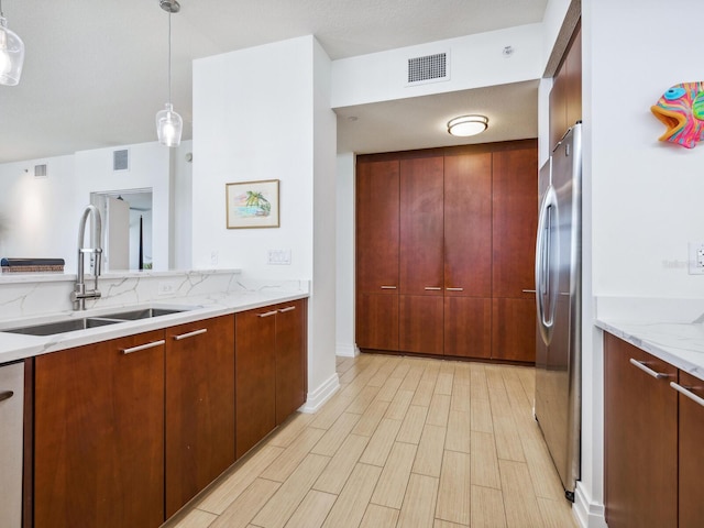 6512 Midnight Pass Rd Unit 301, Sarasota, FL 34242 - kitchen with a sink, freestanding refrigerator, light stone counters, backsplash, and hanging light fixtures