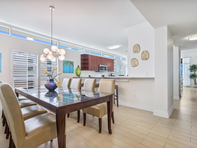 6512 Midnight Pass Rd Unit 301, Sarasota, FL 34242 - dining room with a chandelier, baseboards, and light wood finished floors