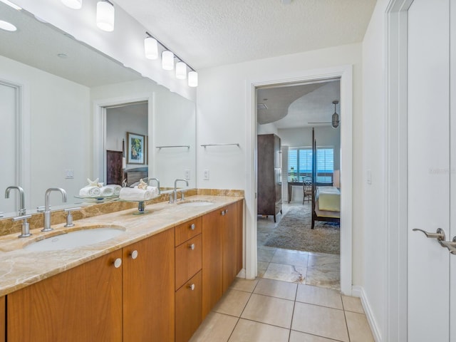 6512 Midnight Pass Rd Unit 301, Sarasota, FL 34242 - ensuite bathroom featuring double vanity, a textured ceiling, and baseboards
