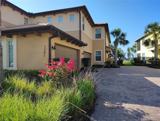 1241 Riverscape St Unit B, Bradenton, FL 34208 - view of property exterior with stucco siding, a garage, and driveway