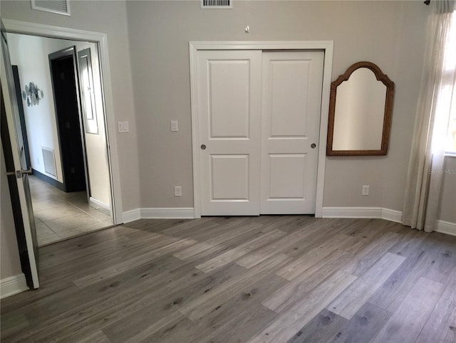 1241 Riverscape St Unit B, Bradenton, FL 34208 - unfurnished bedroom featuring wood finished floors, a closet, and baseboards