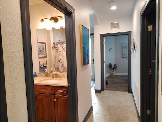 1241 Riverscape St Unit B, Bradenton, FL 34208 - corridor featuring light tile patterned floors, a sink, arched walkways, and baseboards