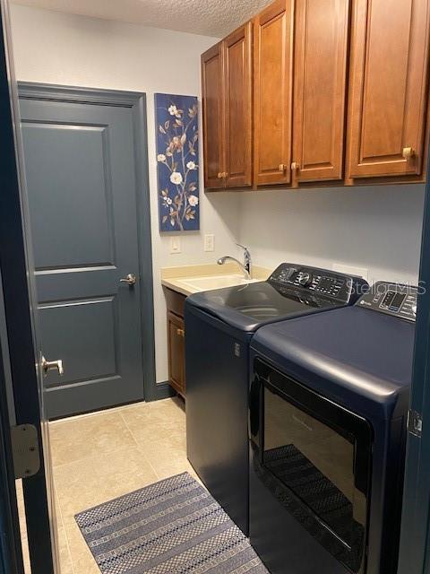 1241 Riverscape St Unit B, Bradenton, FL 34208 - washroom featuring washing machine and clothes dryer, cabinet space, and a textured ceiling