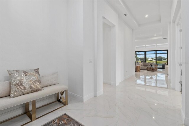 8982 Baroque Ter, Sarasota, FL 34240 - hall featuring marble tiled floors, baseboards, a tray ceiling, and recessed lighting