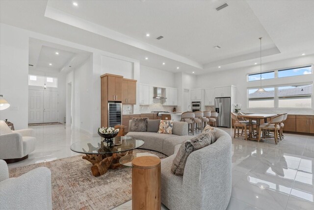 8982 Baroque Ter, Sarasota, FL 34240 - living area featuring a tray ceiling, beverage cooler, a towering ceiling, recessed lighting, and light marble finish floors