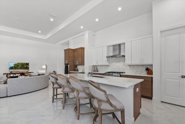 8982 Baroque Ter, Sarasota, FL 34240 - kitchen featuring wall chimney exhaust hood, light marble finish floors, a kitchen breakfast bar, decorative backsplash, and recessed lighting