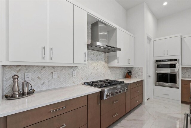 8982 Baroque Ter, Sarasota, FL 34240 - kitchen with wall chimney range hood, stainless steel appliances, white cabinets, light marble finish floors, and light stone countertops