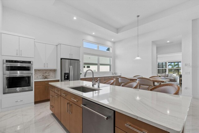 8982 Baroque Ter, Sarasota, FL 34240 - kitchen featuring stainless steel appliances, a sink, recessed lighting, light stone counters, and backsplash