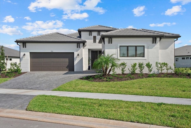 8982 Baroque Ter, Sarasota, FL 34240 - prairie-style house with an attached garage, a front lawn, decorative driveway, stucco siding, and a tile roof