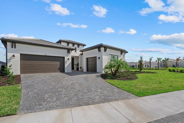 8982 Baroque Ter, Sarasota, FL 34240 - prairie-style house featuring a garage, a front yard, decorative driveway, and stucco siding