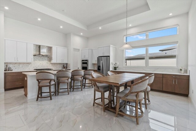 8982 Baroque Ter, Sarasota, FL 34240 - dining area featuring a towering ceiling, recessed lighting, light marble finish floors, and a tray ceiling