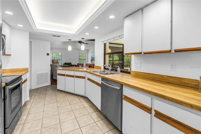 435 Whispering Oaks Ct, Sarasota, FL 34232 - kitchen with stainless steel appliances, a sink, wood counters, recessed lighting, and white cabinets