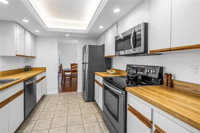 435 Whispering Oaks Ct, Sarasota, FL 34232 - kitchen featuring stainless steel appliances, butcher block countertops, recessed lighting, white cabinetry, and a tray ceiling