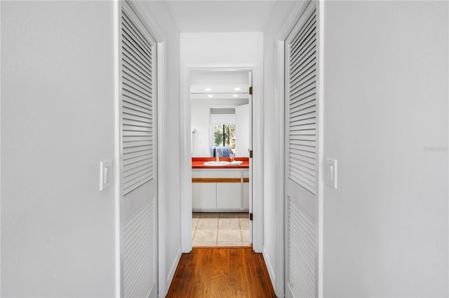 435 Whispering Oaks Ct, Sarasota, FL 34232 - corridor featuring recessed lighting, a sink, and wood finished floors