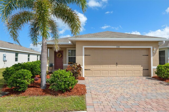 5358 Shell Mound Cir, Punta Gorda, FL 33982 - ranch-style house with stucco siding, an attached garage, and decorative driveway