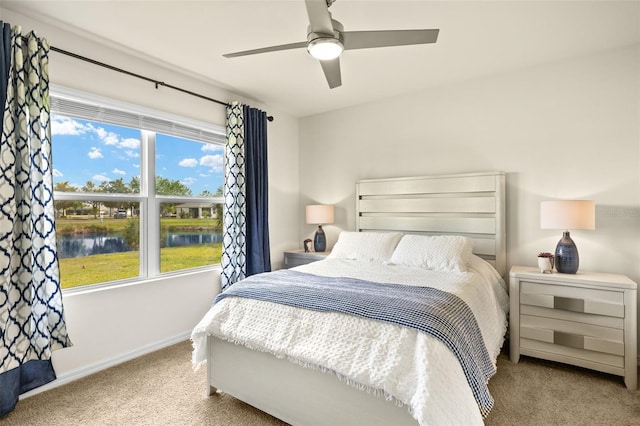 5358 Shell Mound Cir, Punta Gorda, FL 33982 - carpeted bedroom with multiple windows, a water view, baseboards, and a ceiling fan