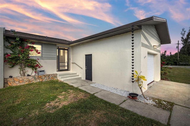 3203 Riverside Dr Unit B, Punta Gorda, FL 33950 - back of house featuring concrete driveway, stucco siding, a lawn, and a garage