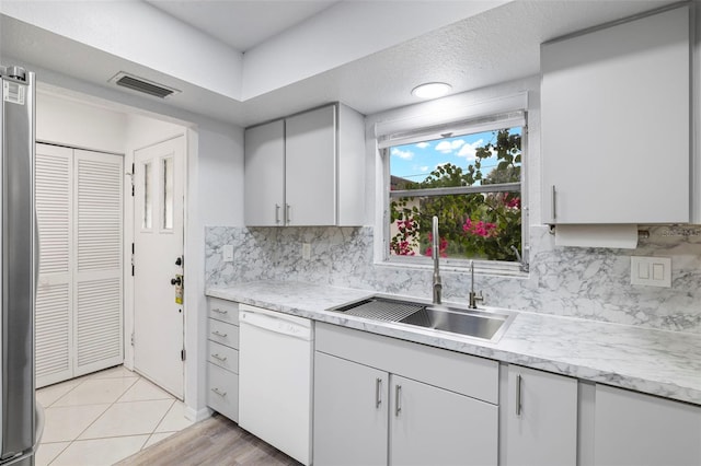 3203 Riverside Dr Unit B, Punta Gorda, FL 33950 - kitchen featuring white dishwasher, a sink, light countertops, and tasteful backsplash