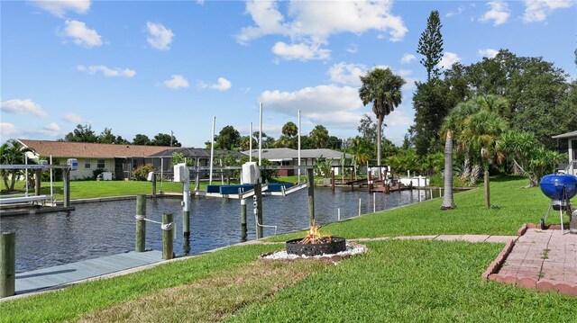3203 Riverside Dr Unit B, Punta Gorda, FL 33950 - dock area with boat lift, a fire pit, a lawn, and a water view