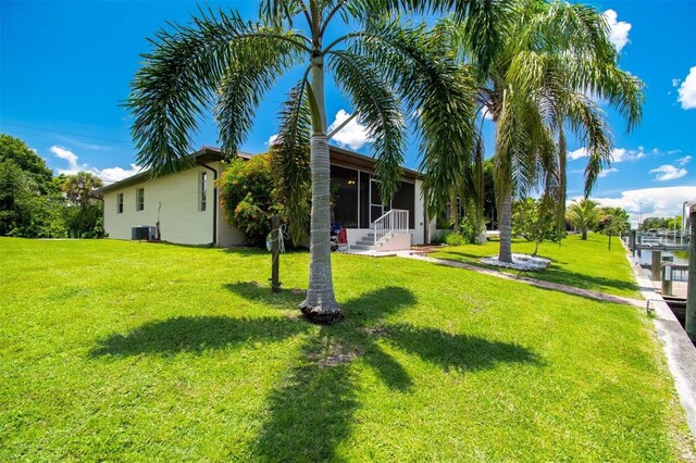 3203 Riverside Dr Unit B, Punta Gorda, FL 33950 - view of green lawn with a sunroom and cooling unit