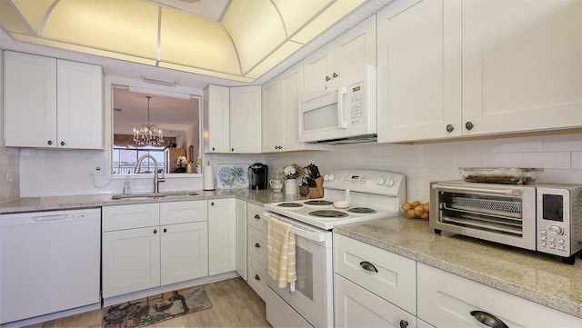 8897 Midnight Pass Rd Unit 407, Sarasota, FL 34242 - kitchen featuring white appliances, a sink, a chandelier, white cabinets, and backsplash