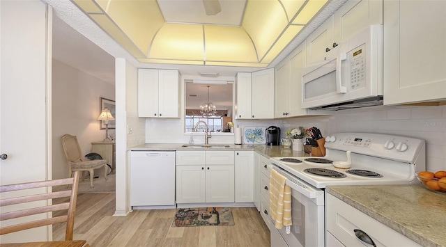 8897 Midnight Pass Rd Unit 407, Sarasota, FL 34242 - kitchen featuring white appliances, a sink, light wood-style floors, light countertops, and decorative backsplash
