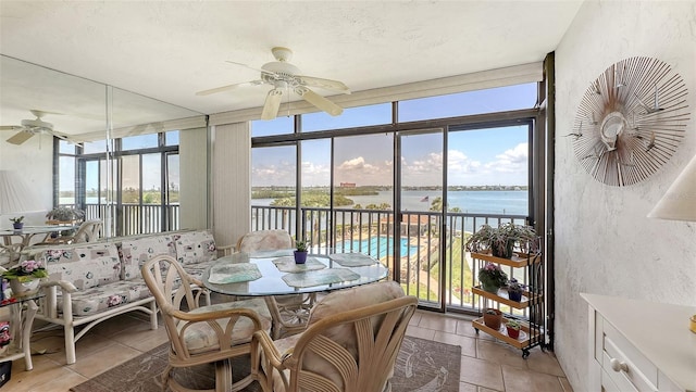 8897 Midnight Pass Rd Unit 407, Sarasota, FL 34242 - sunroom / solarium featuring a water view, healthy amount of natural light, tile patterned floors, a wall of windows, and a textured wall