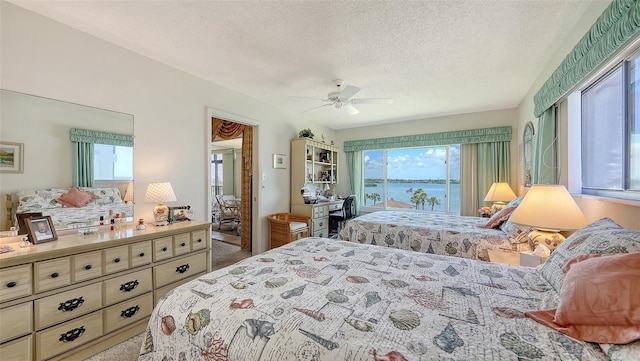8897 Midnight Pass Rd Unit 407, Sarasota, FL 34242 - bedroom with multiple windows, a textured ceiling, a water view, and carpet flooring