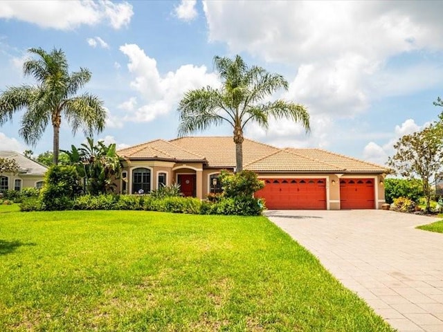 312 148th Ct NE, Bradenton, FL 34212 - view of front of property featuring a garage, a front yard, stucco siding, decorative driveway, and a tile roof