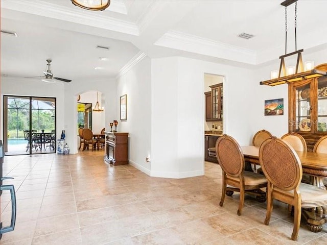 312 148th Ct NE, Bradenton, FL 34212 - dining room with ornamental molding, arched walkways, ceiling fan, baseboards, and a raised ceiling