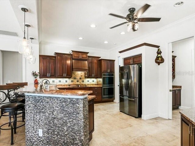 312 148th Ct NE, Bradenton, FL 34212 - kitchen with appliances with stainless steel finishes, backsplash, a breakfast bar, ceiling fan, and dark stone countertops