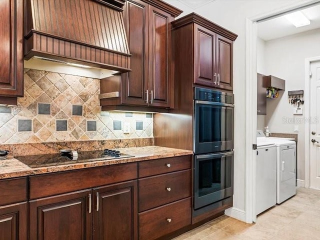 312 148th Ct NE, Bradenton, FL 34212 - kitchen with independent washer and dryer, stainless steel double oven, custom range hood, black electric cooktop, and tasteful backsplash