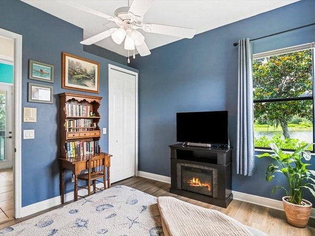 312 148th Ct NE, Bradenton, FL 34212 - living area with baseboards, wood finished floors, a glass covered fireplace, and ceiling fan