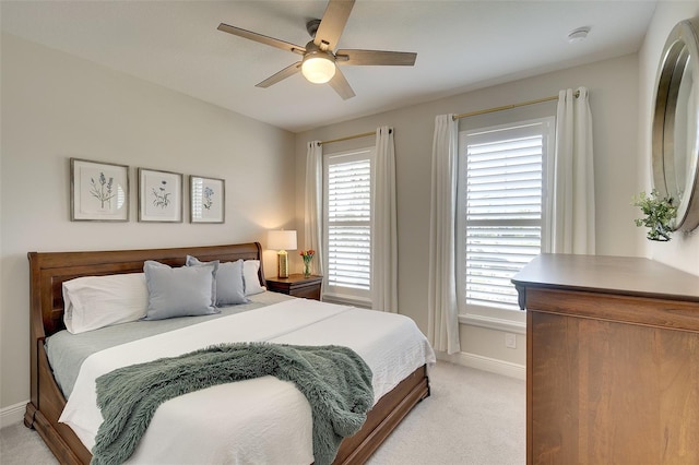8077 Sandstar Way, Sarasota, FL 34240 - bedroom featuring light carpet, baseboards, multiple windows, and a ceiling fan