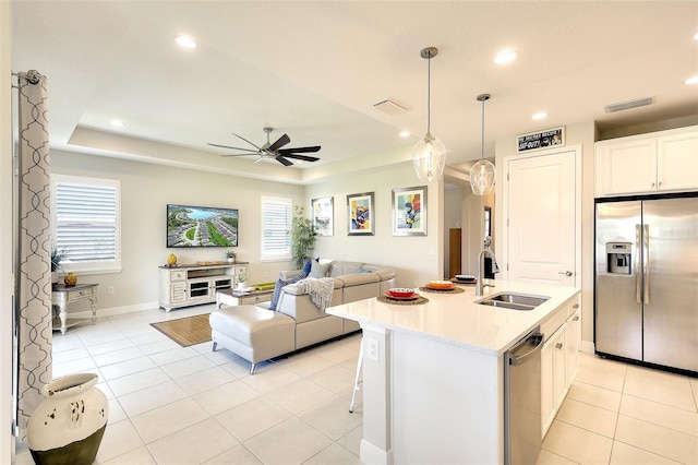 8077 Sandstar Way, Sarasota, FL 34240 - kitchen featuring appliances with stainless steel finishes, a sink, open floor plan, a ceiling fan, and light countertops