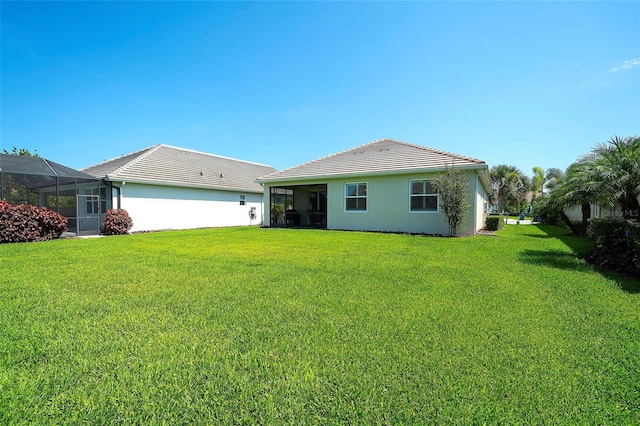 8077 Sandstar Way, Sarasota, FL 34240 - rear view of house featuring a yard, stucco siding, and a tiled roof