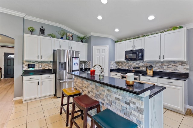 5618 Sheer Bliss Loop, Land O Lakes, FL 34639 - kitchen with stainless steel appliances, crown molding, arched walkways, light tile patterned floors, and white cabinetry