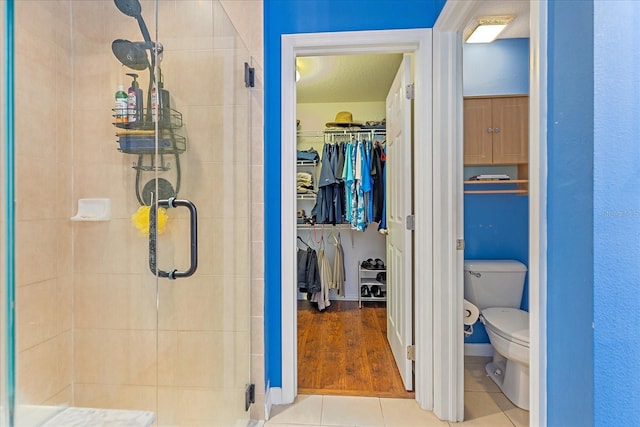 5618 Sheer Bliss Loop, Land O Lakes, FL 34639 - full bath featuring a stall shower, toilet, a walk in closet, and tile patterned floors