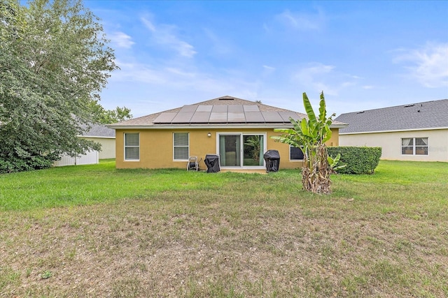 5618 Sheer Bliss Loop, Land O Lakes, FL 34639 - back of property featuring solar panels, stucco siding, and a lawn