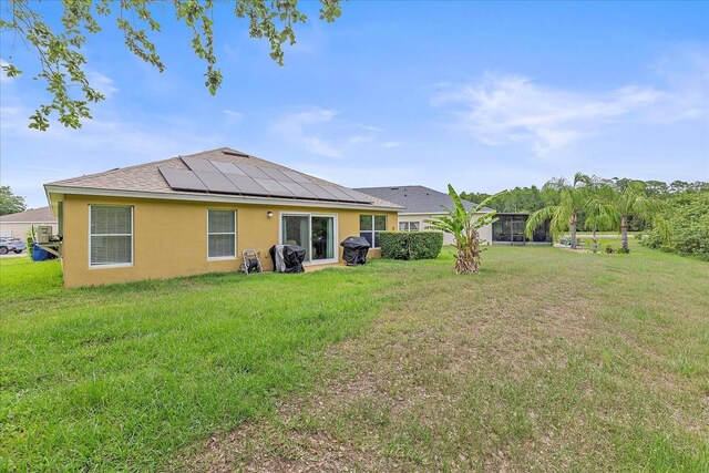 5618 Sheer Bliss Loop, Land O Lakes, FL 34639 - rear view of property featuring stucco siding, solar panels, and a yard