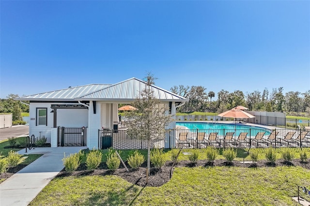4323 112th St E, Palmetto, FL 34221 - view of front facade with metal roof, stucco siding, and a community pool