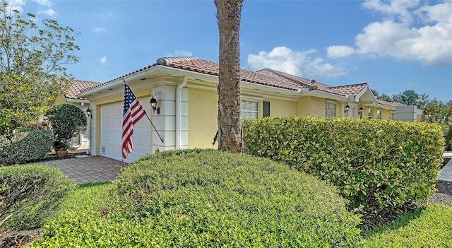 5566 Avellino Pl, Sarasota, FL 34238 - mediterranean / spanish-style home featuring a garage, a tiled roof, and stucco siding