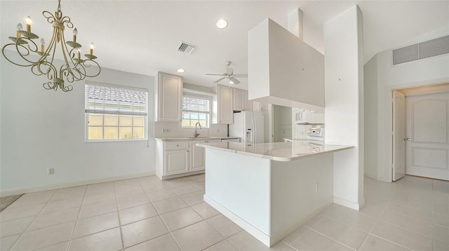 5566 Avellino Pl, Sarasota, FL 34238 - kitchen with white refrigerator with ice dispenser, range, a ceiling fan, a peninsula, and baseboards