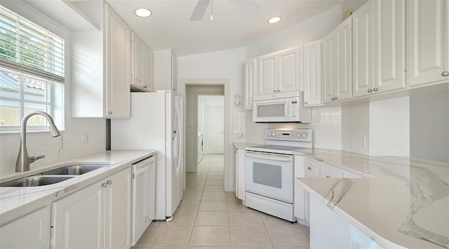 5566 Avellino Pl, Sarasota, FL 34238 - kitchen with white appliances, a sink, white cabinetry, backsplash, and a ceiling fan