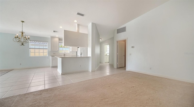 5566 Avellino Pl, Sarasota, FL 34238 - unfurnished living room with a chandelier, light tile patterned floors, light colored carpet, baseboards, and lofted ceiling
