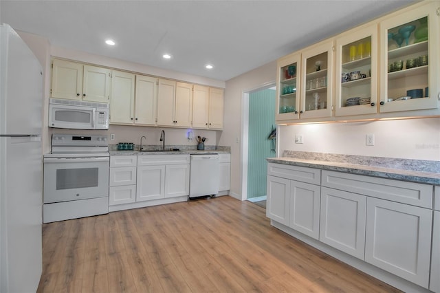 951 Varet Rd, Venice, FL 34293 - kitchen with white appliances, a sink, light wood finished floors, recessed lighting, and glass insert cabinets