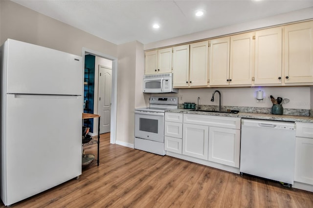 951 Varet Rd, Venice, FL 34293 - kitchen with white appliances, a sink, light wood finished floors, baseboards, and light stone countertops