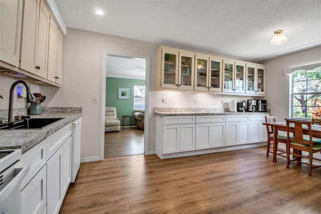 951 Varet Rd, Venice, FL 34293 - kitchen with a sink, light countertops, light wood-type flooring, glass insert cabinets, and white appliances