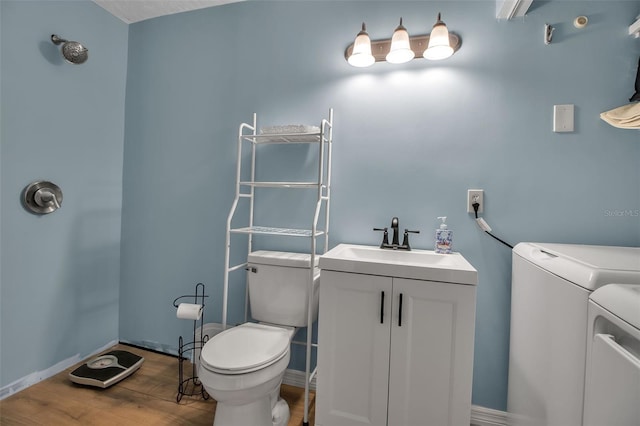 951 Varet Rd, Venice, FL 34293 - bathroom with washer and dryer, toilet, wood finished floors, vanity, and baseboards
